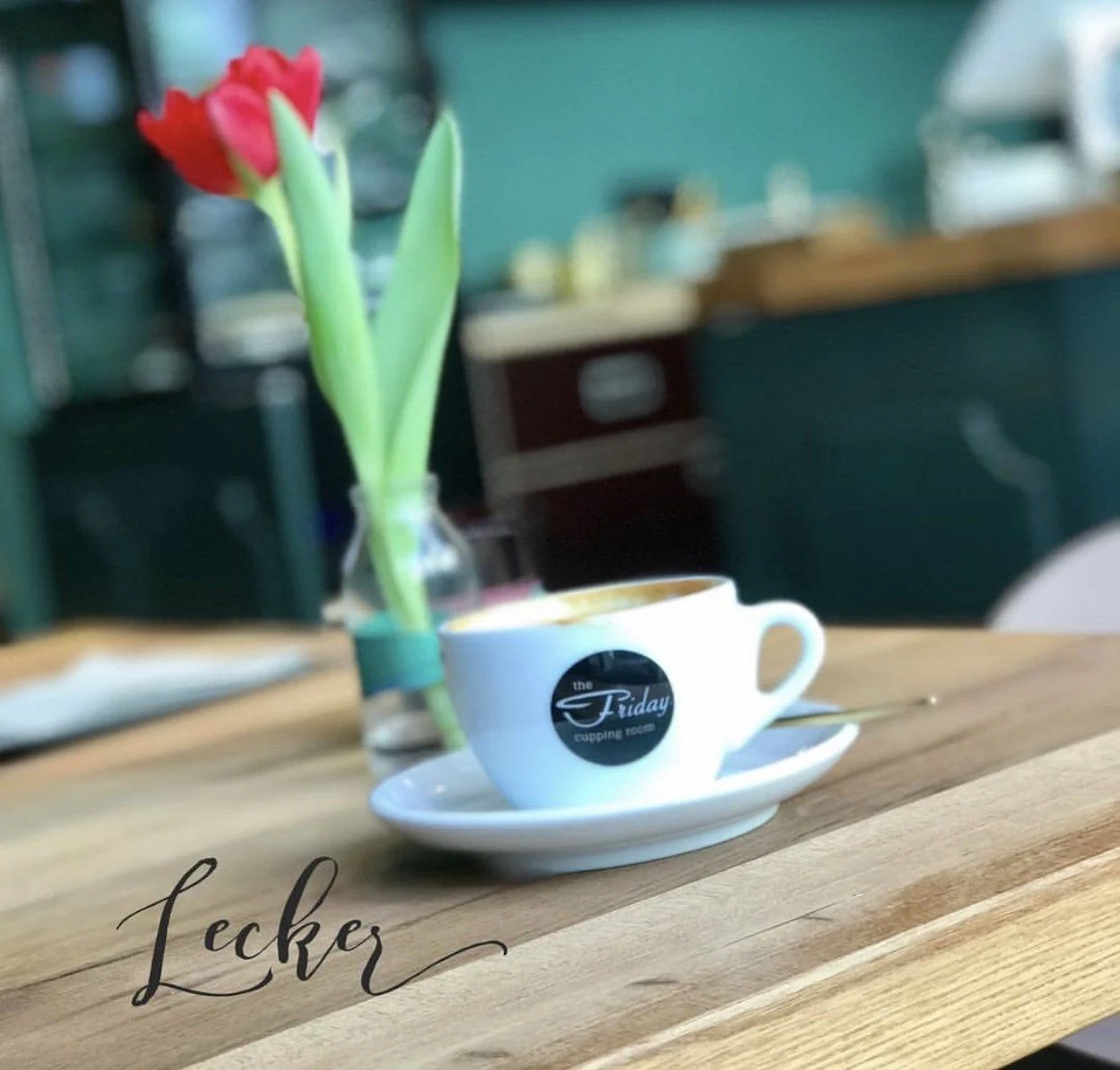 Kaffeetasse und Blumen auf einem Holztisch im THE FRIDAY
