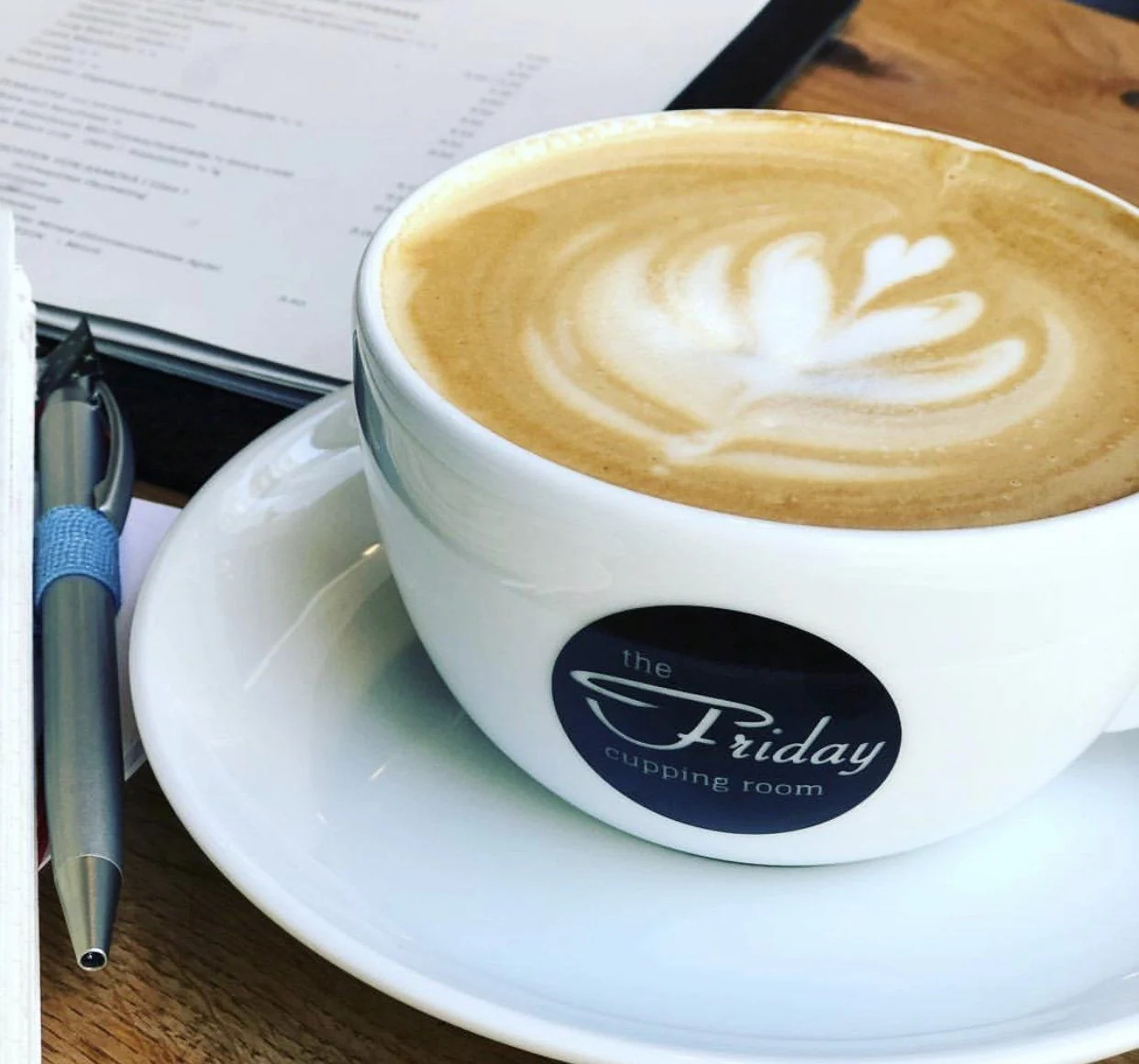 Cappuccino mit Latte Art und dem Original-Logo von THE FRIDAY