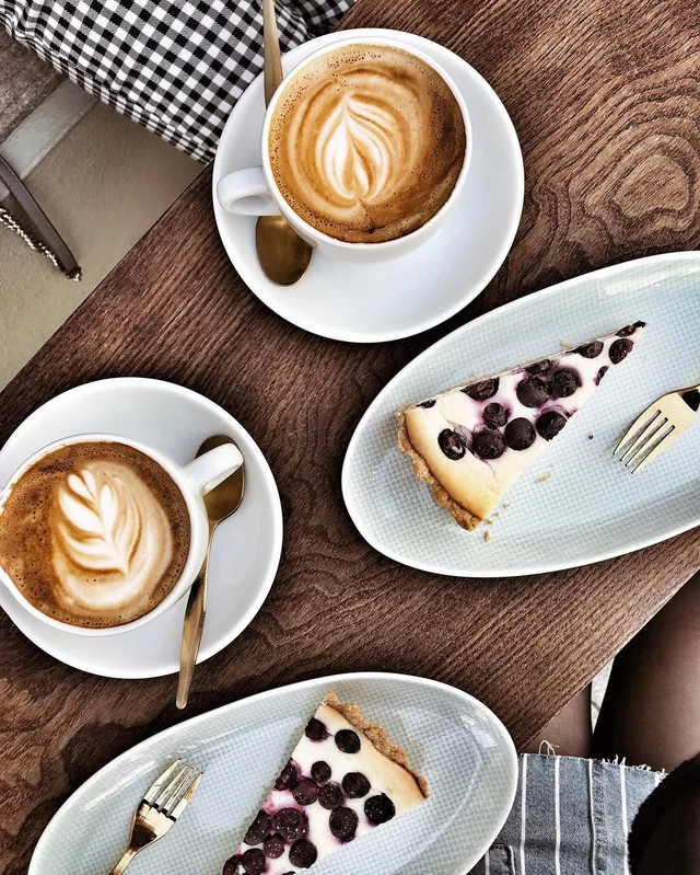 Zwei Kaffees und selbstgebackener Kuchen auf einem Tisch im THE FRIDAY