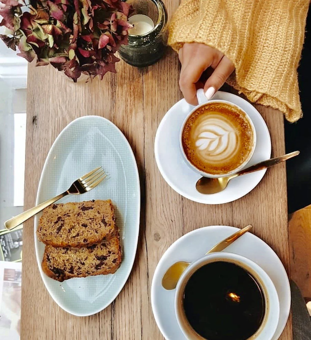Kaffee und Kuchen auf einem Holztisch im THE FRIDAY